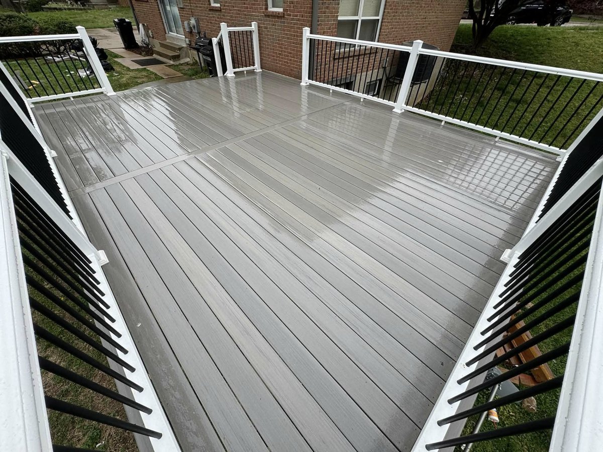 Clean gray composite decking surface with white railing built by Freedom Home Improvements